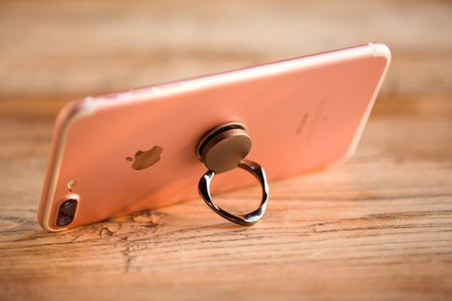 An iPhone with a ring shaped stand stuck to the back