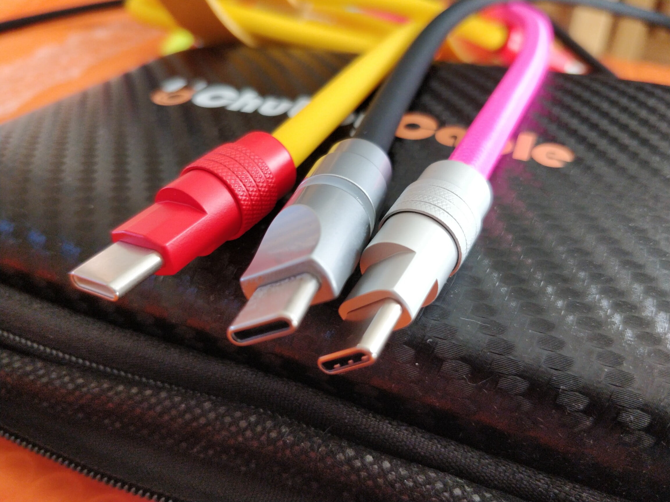 USB-C cables one is red and yellow, one black and sliver, the other hot pink.